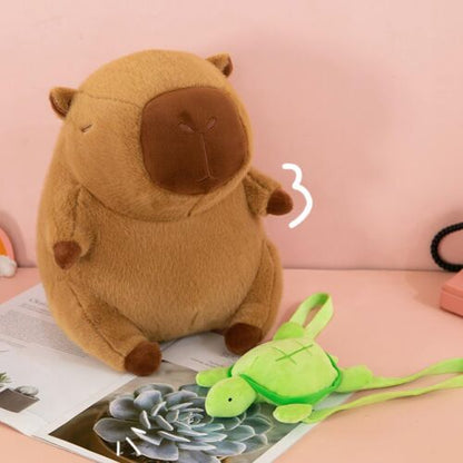 DreamPets kapibara plüssfigura, zöld béka kiegészítővel asztalon