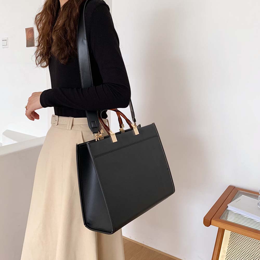 fekete strukturált női crossbody kézitáska modellen, vállon viselt oldalnézetben