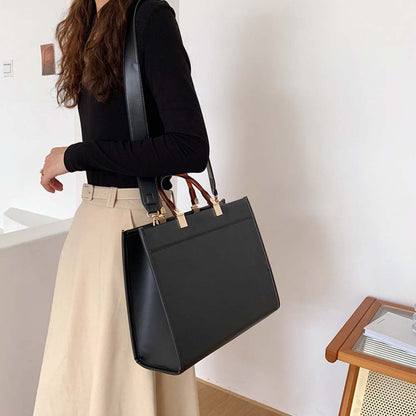 fekete strukturált női crossbody kézitáska modellen, vállon viselt oldalnézetben