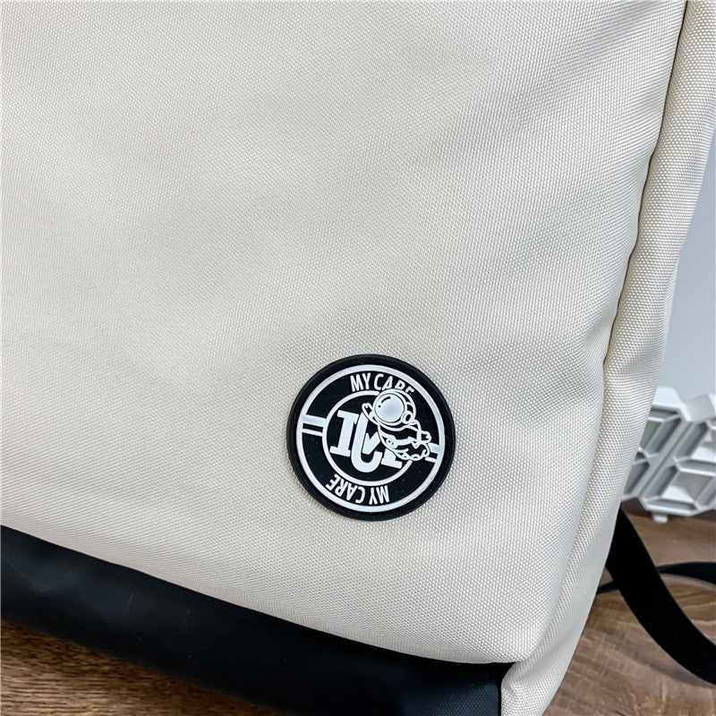 krémszínű uniszex laptop hátizsák alsó logó és anyagrészlet közelképen