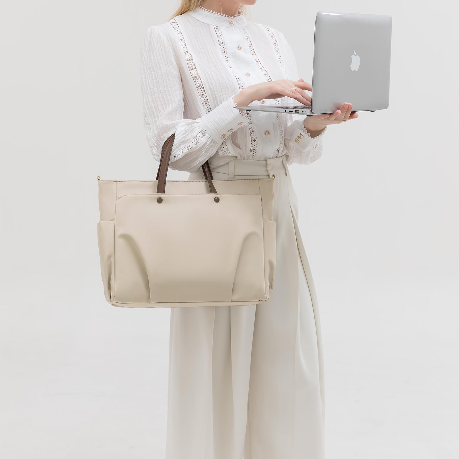 bézs vízlepergető női laptop válltáska modellen, laptopot kézben tartva