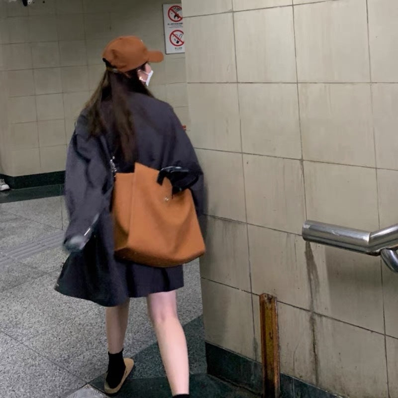 barna női műbőr laptoptáska modellen hátulról hordva metróállomási jelenetben