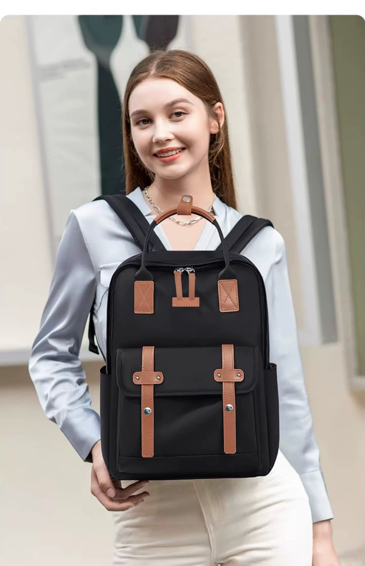 fekete bővíthető laptop hátizsák modellen, kézben tartva barna pántdíszekkel
