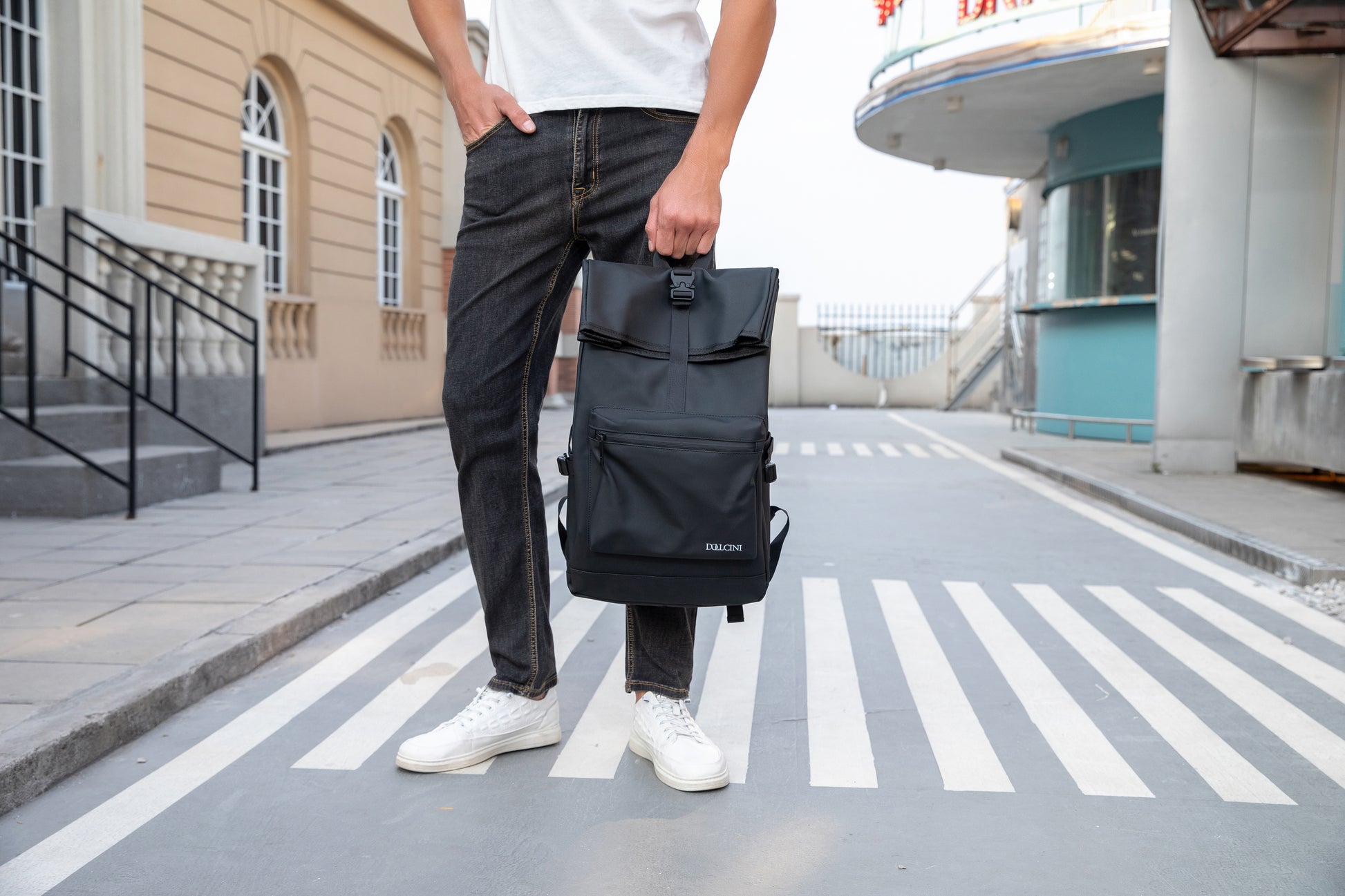 fekete oxford laptop hátizsák kézben tartva zebrán fotózott utazós nézetben