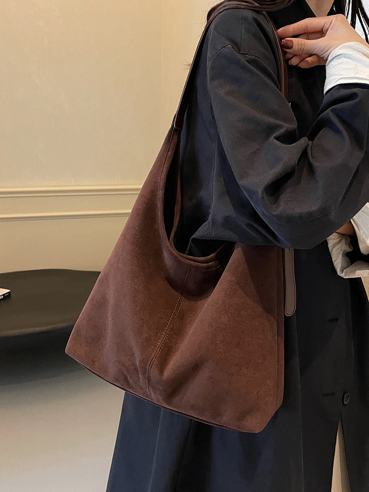 barna nagy méretű hobo válltáska modellen, vállon viselt közeli nézetben