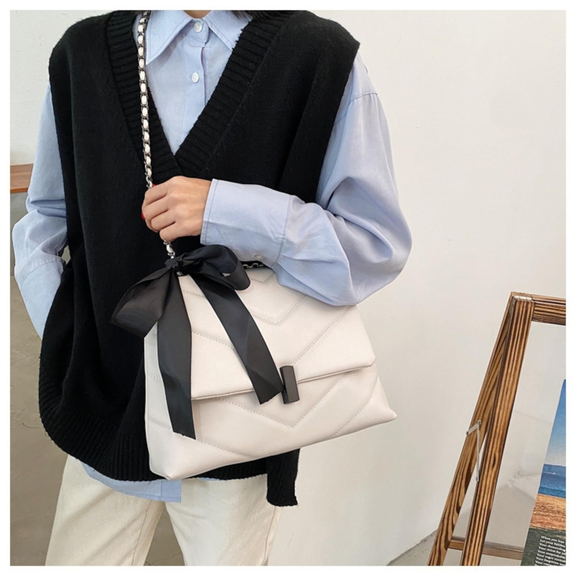 fehér steppelt női crossbody táska modellen elöl hordva fekete masnival