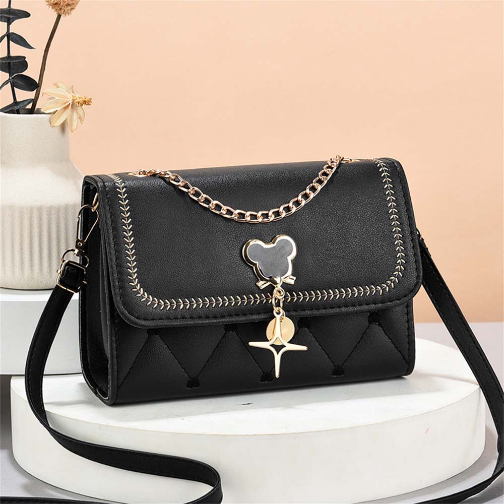 fekete steppelt női crossbody táska asztali termékfotón arany lánccal