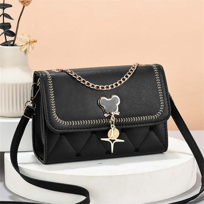 fekete steppelt női crossbody táska asztali termékfotón arany lánccal